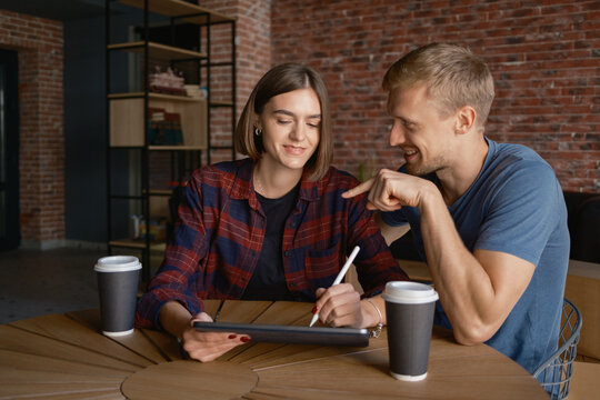 Two colleagues brainstorming and collaborating while using a tablet in a relaxed setting