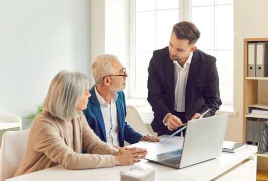 Adviser, agent, or consultant is helping a pair of senior clients with insurance and financial investments during a meeting in the office. Importance of financial planning and insurance for elderly.