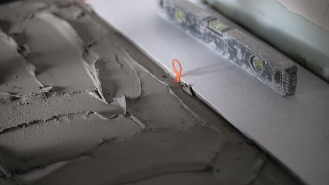 Applying tile adhesive and installing floor tiles