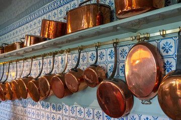 Copper pans lined up on a kitchen wall