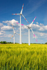 Cover page with beautiful green farm landscape with light and shadow waves in Germany with clouds in sky, and wind turbines to generate electrical power.