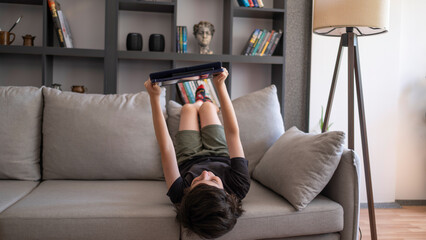 Child lying on couch using tablet