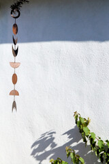 Minimalist Hanging Metal Moon Mobile Casting Shadow on White Wall
