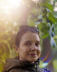 Portrait of smiling brunette woman enjoying wonderful sunny day in nature