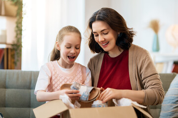 Mother and daughter are unpacking cardboard