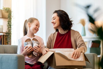 Mother and daughter are unpacking cardboard