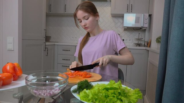 Young Left-Handed Teen Girl Scrupulously Slices Fresh Tomatoes On Wooden Cutting Board, Prepares Nutritious Dish With Crispy Lettuce Leaves And Onions In Bright, Hospitable Home Cooking