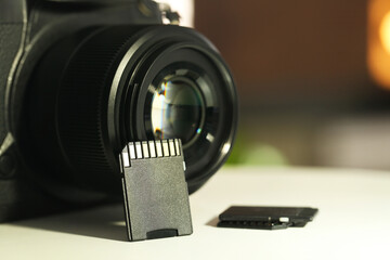 SD memory cards and photo camera on white table, closeup