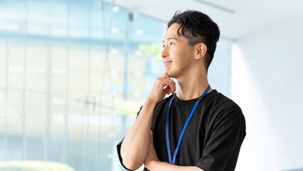 考えごとをする笑顔の男性ビジネスマン