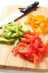 Slices of fresh colorful bell peppers on white table, closeup