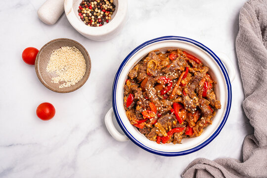 Stir-fried Beef Skirt Steak and Paprika with Oyster Sauce in a bowl on white background. Top view with copy space