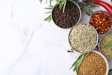 Different aromatic spices on white marble table, flat lay. Space for text