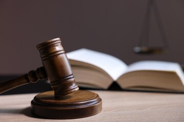 Judge's gavel and book on wooden table, closeup