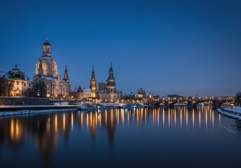 The stunning night view of the Dresden skyline with lights reflecting on the river.