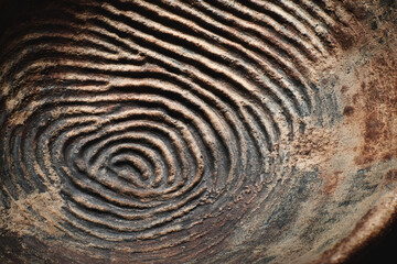 Naklejka premium Close up macro texture of a fingerprint impression in aged clay or mud with concentric circles