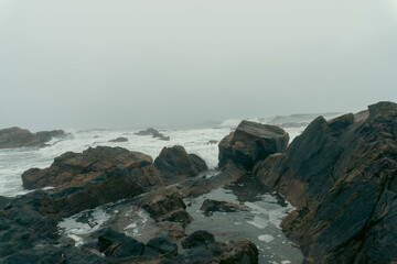 Misty Portuguese winter coastline with rocky shores and melancholic atmosphere