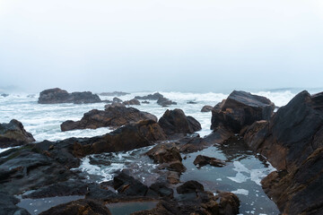 Misty Portuguese winter coastline with rocky shores and melancholic atmosphere