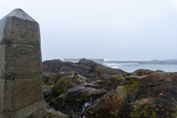 Misty Portuguese winter coastline with rocky shores and melancholic atmosphere