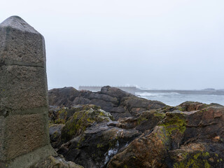 Misty Portuguese winter coastline with rocky shores and melancholic atmosphere
