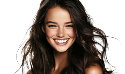 Smiling young woman with long wavy hair, bright eyes, and radiant skin against a dark background, showcasing beauty and happiness in a cheerful portrait