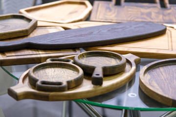 Wooden kitchenware displayed on a glass table at a craft fair