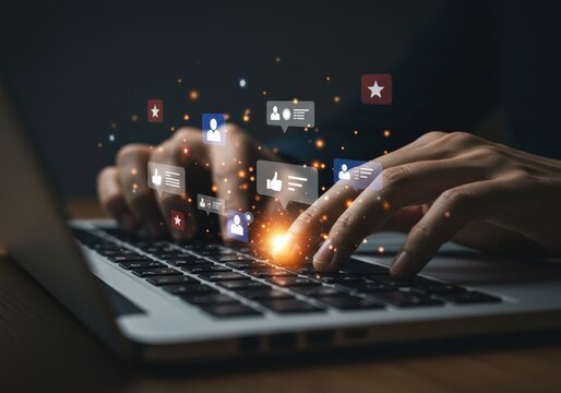 Hands using a laptop, with social media icons indicating online engagement and interaction.