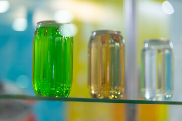 Colorful jars filled with various liquids on a display shelf indoors