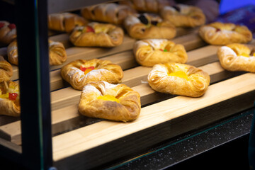 Freshly baked pastries displayed on wooden trays at a bakery showcase