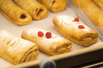 Freshly baked pastries displayed in a bakery case in the morning sunlight