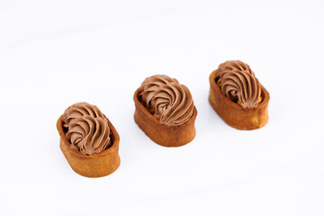 Caramel tartlet, caramelized peanuts, salted caramel, chocolate ganache. Dessert of dough, nut tartlets covered with a layer of caramel. Tartlet with caramelized nuts isolated on white. Tasty dessert