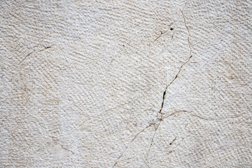 Textured Surface Of A Beige Stone Wall With Natural Cracks