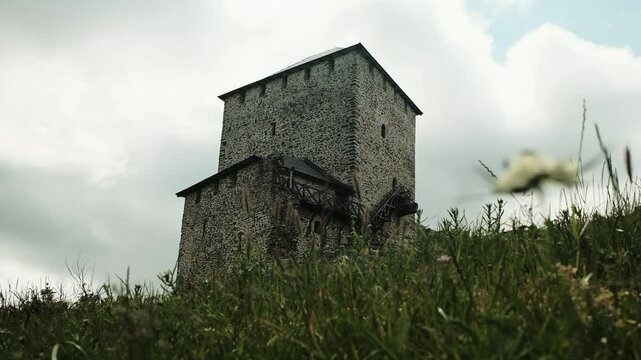 Wide view of Vrsac Fortress on green hill under dramatic spring clouds. Travel in Serbia country concept. A popular tourist destination. 4k horizontal footage.