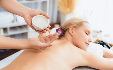 Masseur hands pouring aroma oil on woman back. Masseuse prepare oil massage procedure for customer...