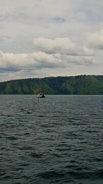 View of the KMP Pora pora ferry sailing on Lake Toba with small waves. Domestic ferry with a fixed route on lake waters. Sailing from Samosir to Parapat and vice versa.