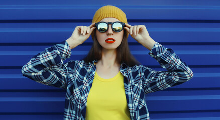 Stylish young woman in colorful clothes, modern teenage girl posing on city street