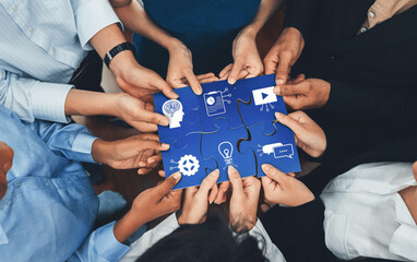 Diverse corporate officer workers collaborate in office, connecting puzzle pieces to represent...