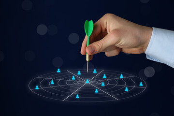 Targeting. Businessman touching aim with arrow on virtual screen against dark background, closeup