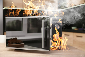 Microwave oven burning inside on table in kitchen