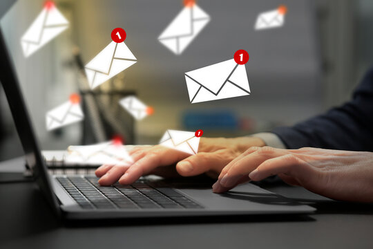 Email marketing, new message notification. Woman using laptop at table, closeup. Envelopes flying out of computer