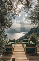 Outdoor wooden deck with green cushions overlooking a lake and mountains. Sunlight streams through trees