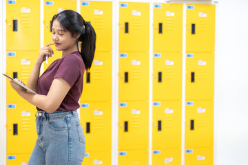 Asian school girls worked on their laptops inside a university classroom while faculty guided them...