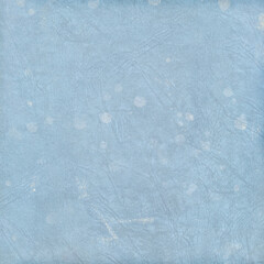Soft blue textured background with subtle scratches and faded spots, vintage abstract surface ideal for scrapbooking, winter themes, invitations, posters, and graphic design projects.