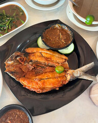Fried pomfret fish served with sambal dip.
