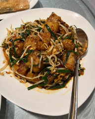 Stir-fried radish cake with vegetables topping.