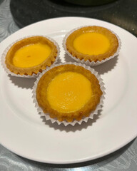 Mini egg tarts sit on round plate.