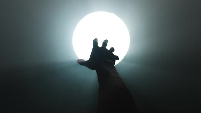 Hand Reaching Toward Light at the End of a Dark Tunnel