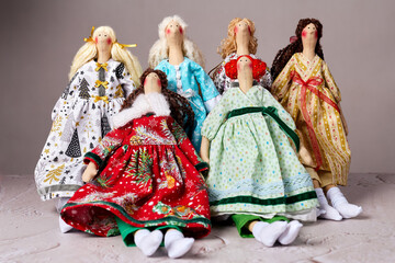 Six handmade fabric dolls in bright dresses, posed together for a festive portrait