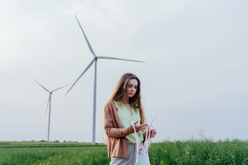 Young woman with reusable mesh bag near wind turbines