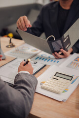 Business team discuss and explain marketing plan to plan financial strategy for business owner using laptop, calculator, chart sheet to calculate and summarize results. Business and finance concept.