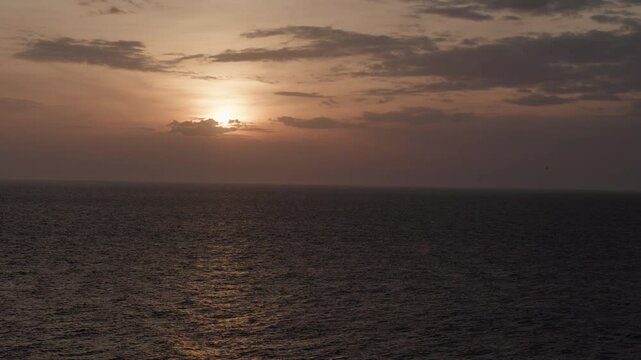 Golden sunlight reflects off the rippling surface of the ocean, creating a shimmering, textured pattern of light and shadow in slow motion. Perfect seascape. ProRes 422 10 bit C-LOG2 video.